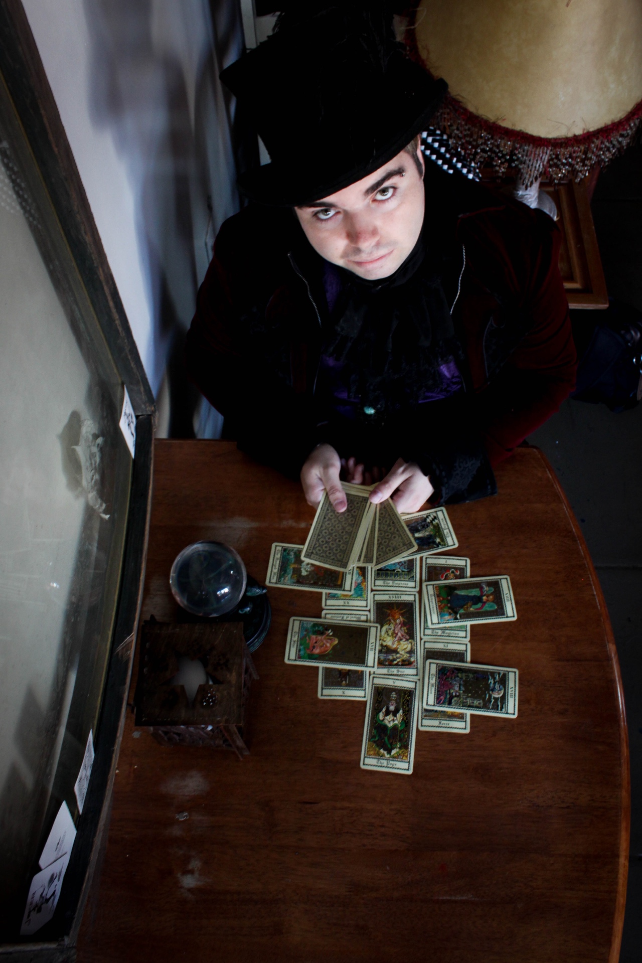 Mystic Dylan in his top hat looking up from his tarot table